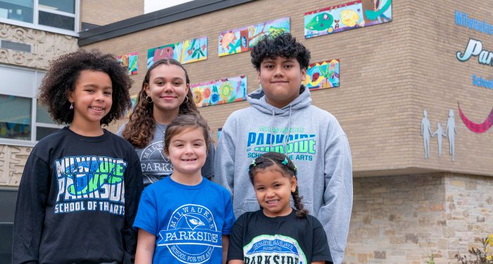 Children wearing Parkside tops stand in front of the school.