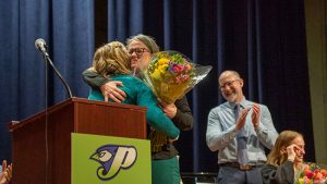 Claudia Heller de Messer accepting a bouquet of flowers.