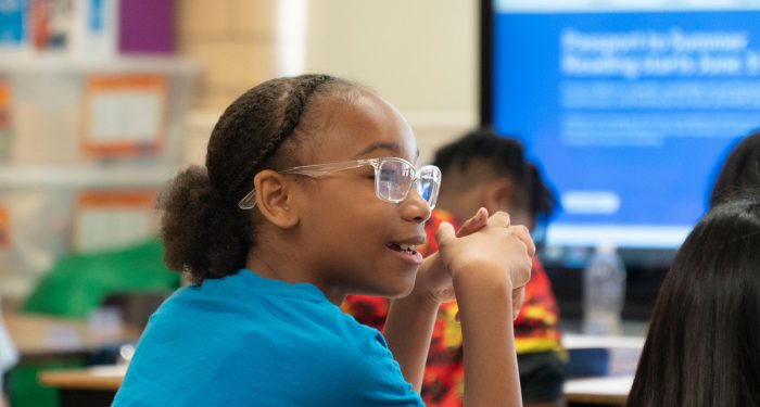 A smiling girl with glasses.