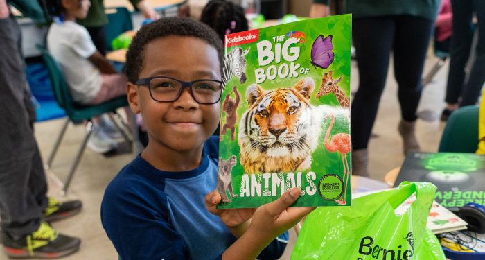 A student holds up the Big Book of Animals.