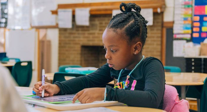 A young student practices writing.