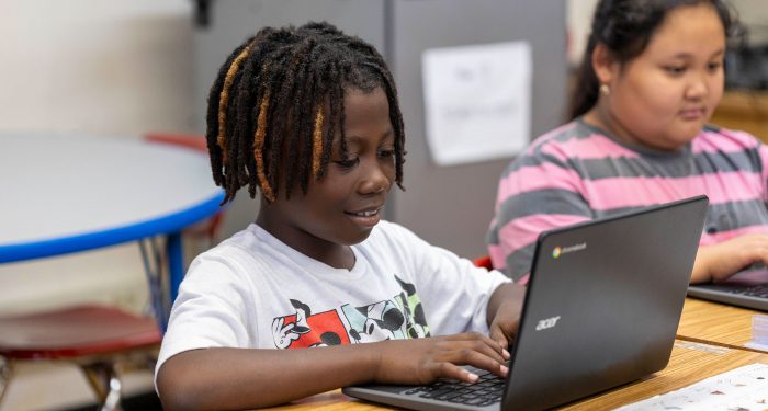 Students type on their computers.