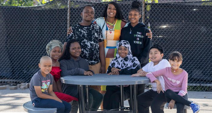 A principal with her students outside at a table.
