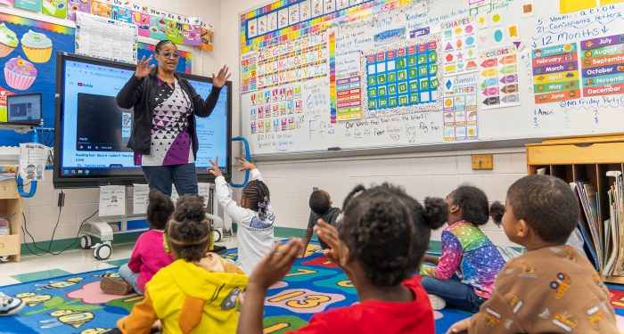 A teacher in front of her young students.