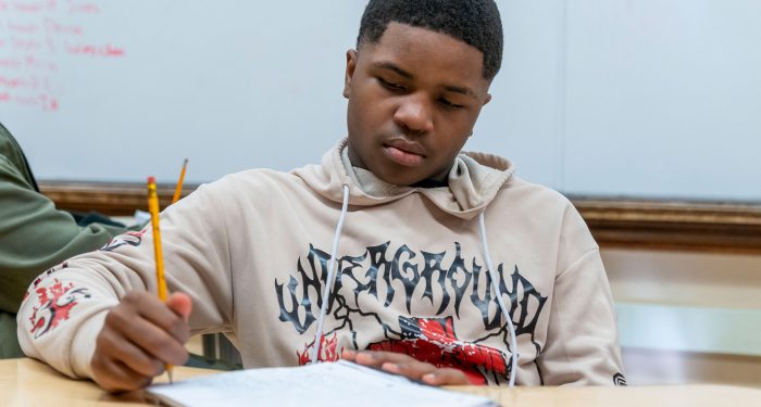 A boy writing in a notebook.