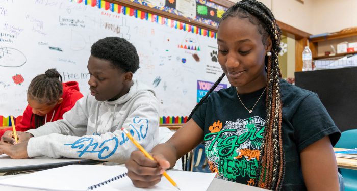Students writing in their notebooks.
