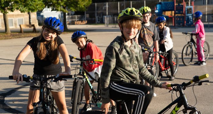 Kids on a playground riding bikes.