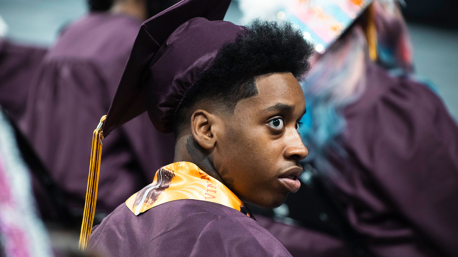 A graduate looking into the crowd.