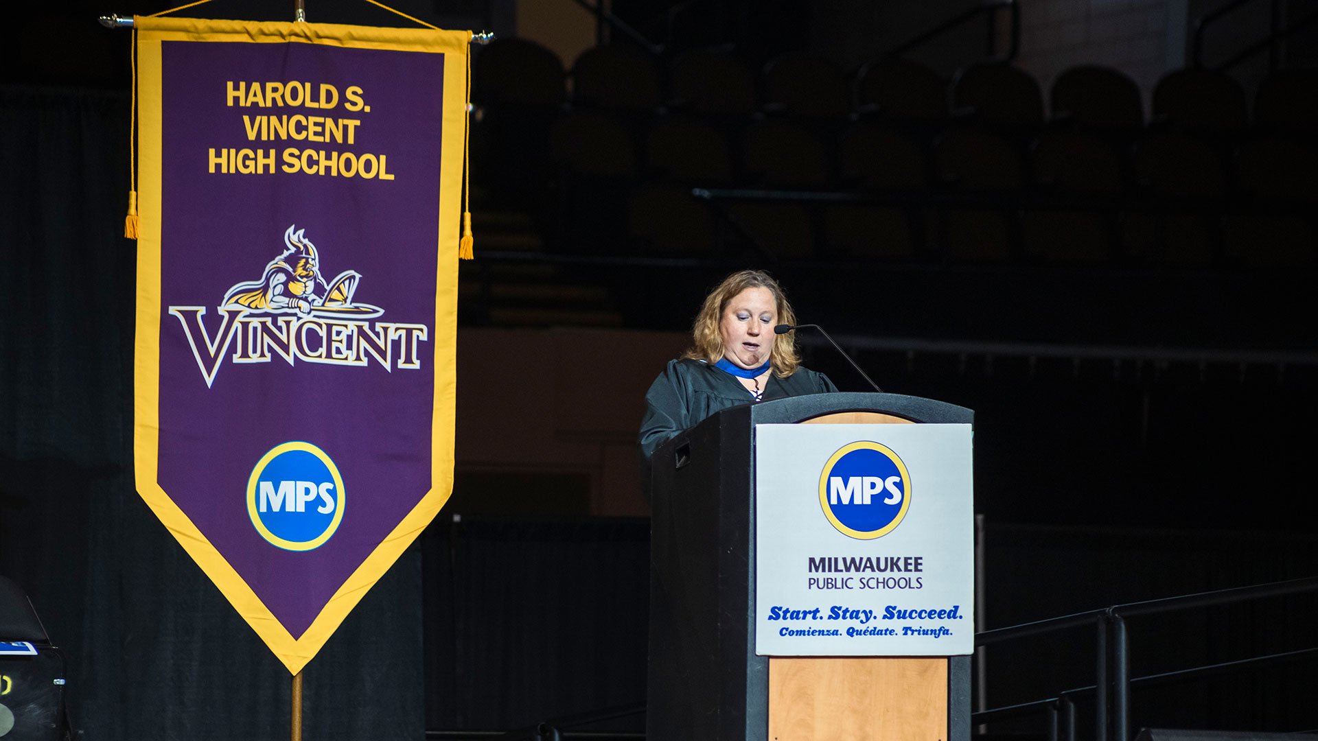 A principal speaking at a podium.