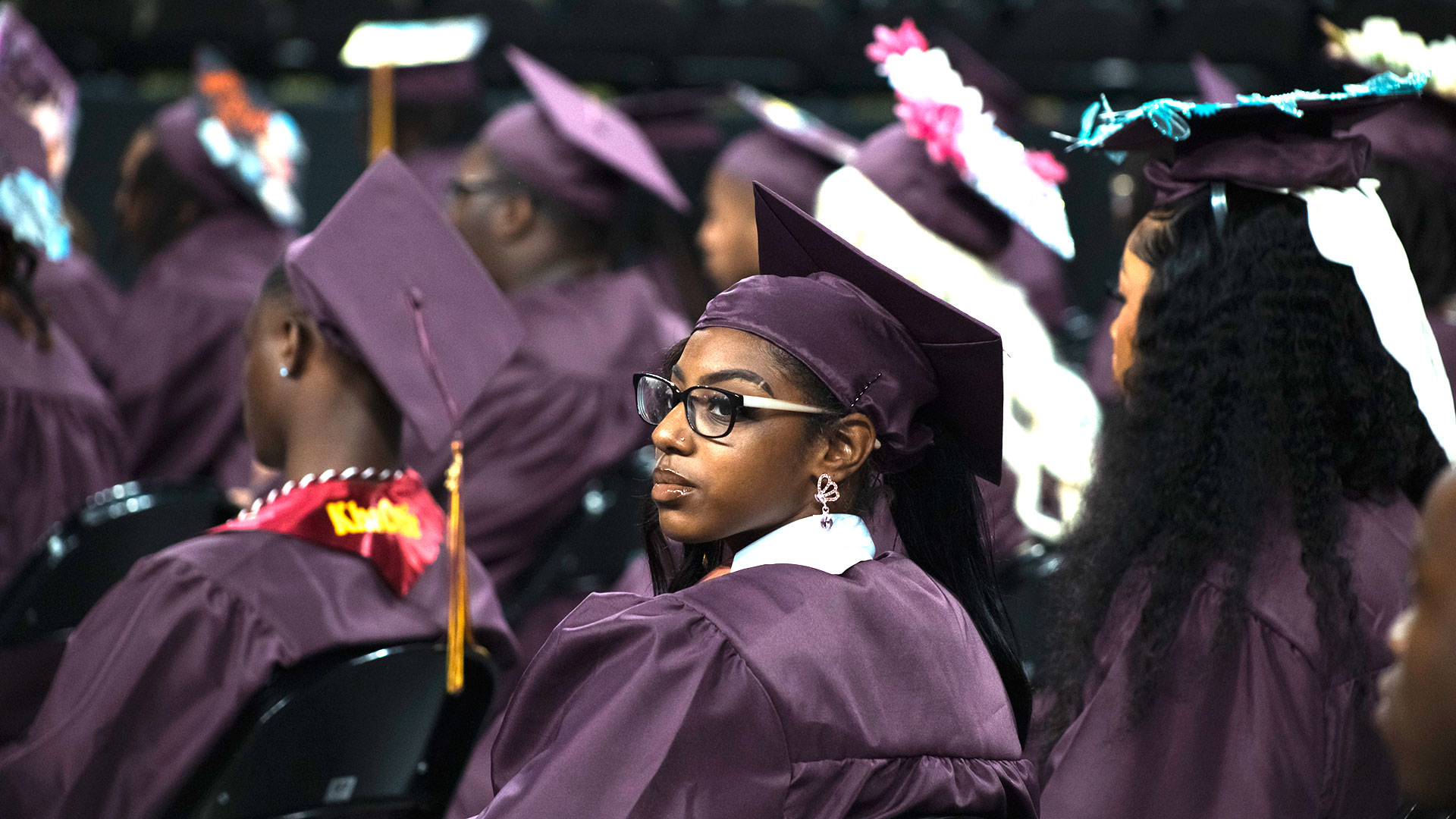 A graduate looking into the crowd.