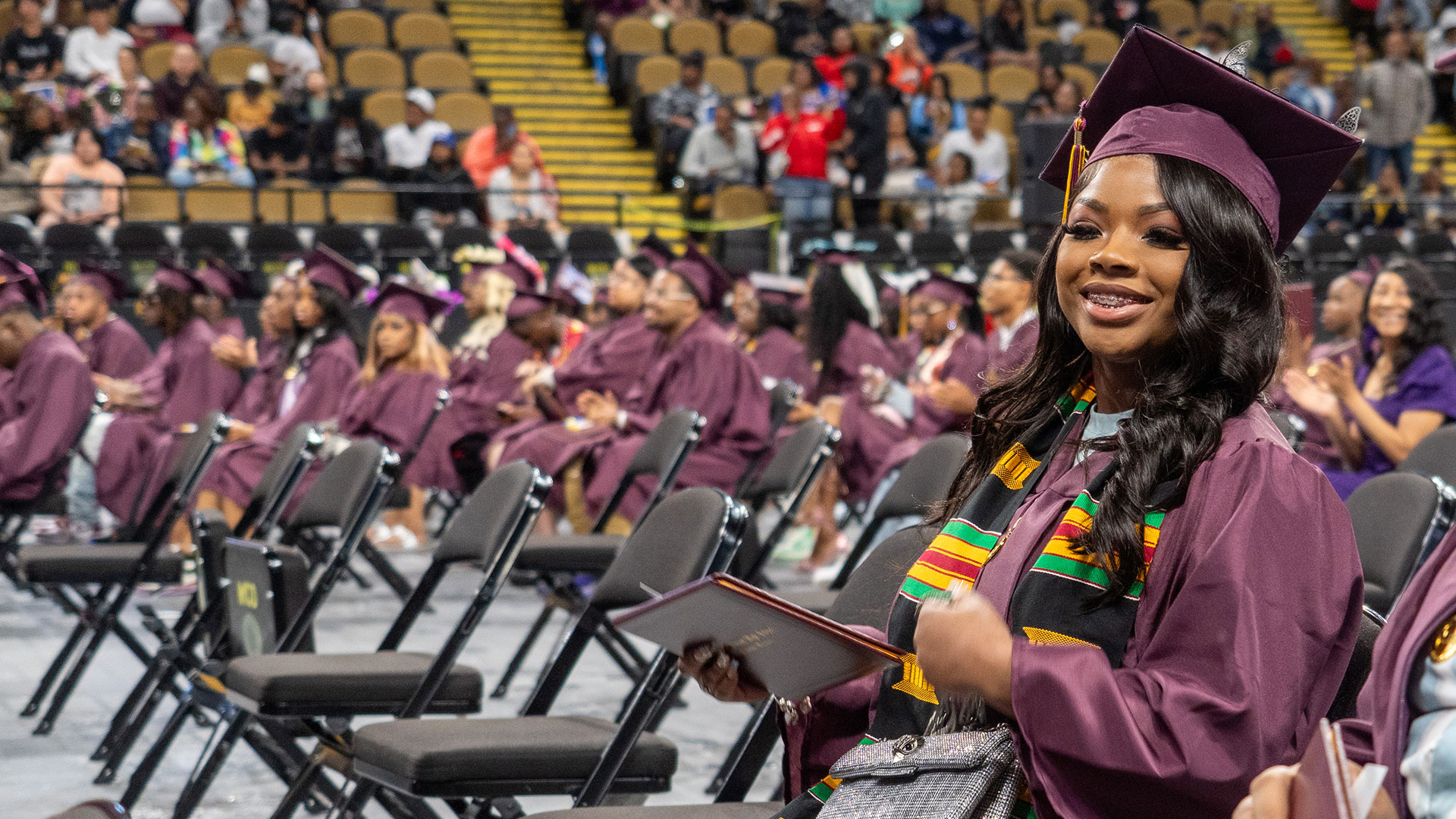 A graduate smiles after receiving their diploma.