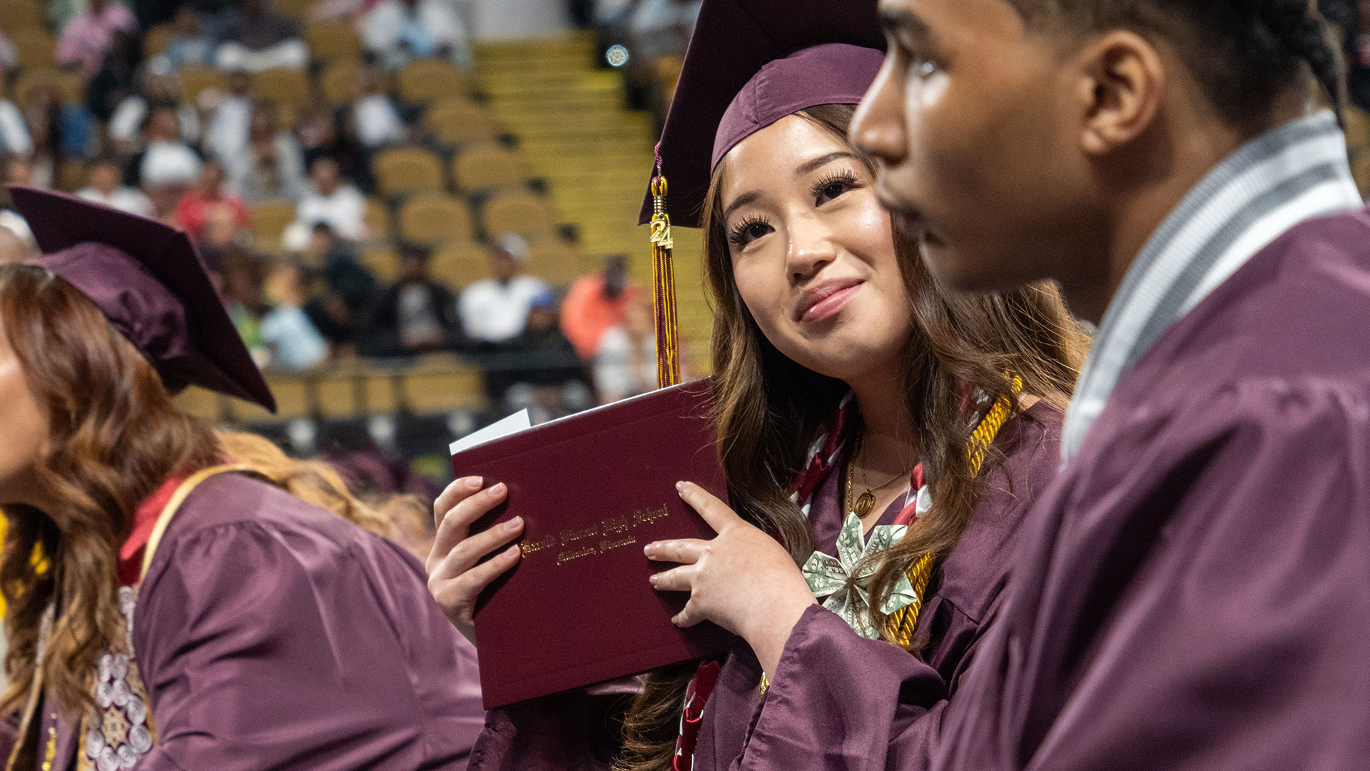 A graduate holding their diploma.