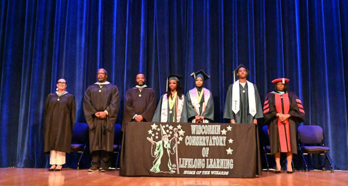 Graduates and staff on the stage.