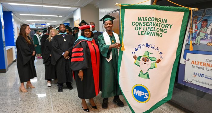 Graduates and staff waiting in the hall before the ceremony.