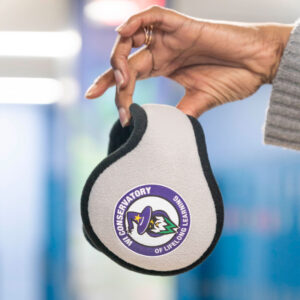 Close-up of a hand holding earmuffs.