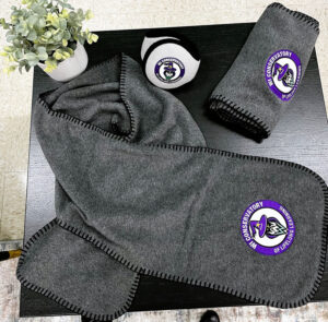 Two scarfs and earmuffs on a table.