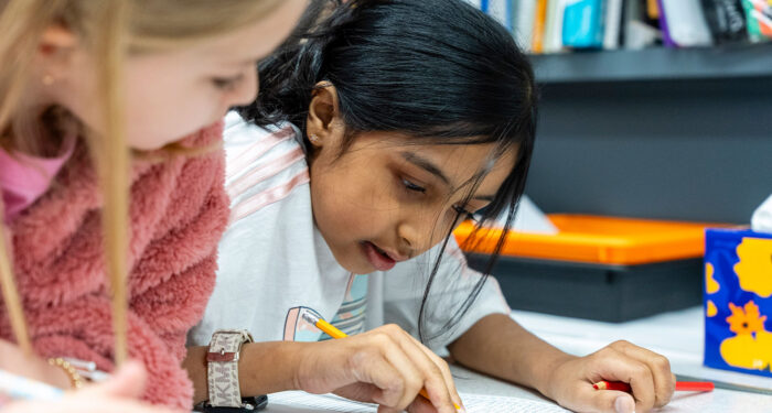 Closeup of two students working together on a project.